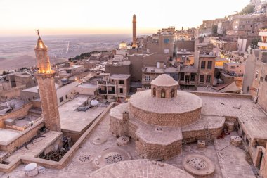 Mardin 'deki Emir Hamami hamamlarının önplanda olduğu eski kentin günbatımı manzarası, Türkiye