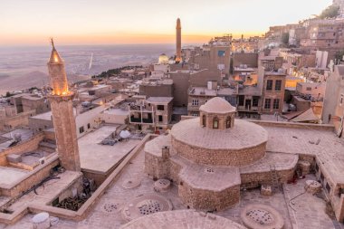 Mardin 'deki Emir Hamami hamamlarının önplanda olduğu eski kentin günbatımı manzarası, Türkiye
