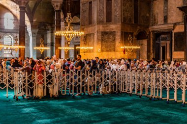 İSTANBUL, TURKEY - 19 Eylül 2022: İstanbul, Türkiye 'deki Ayasofya Tapınağı' nda namaz sırasında çitin arkasındaki turistler