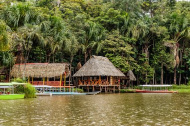 Tingo Maria City, Peru yakınlarındaki Laguna de los Milagros gölünde tekne ve barakalar
