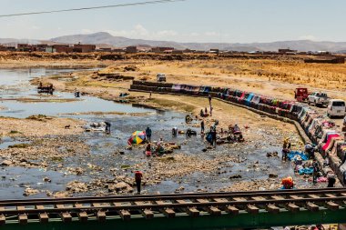 JULIACA, PERU - 6 Kasım 2022: Peru 'nun Juliaca şehrinde Coata Nehri' nde çamaşır yıkayan insanlar