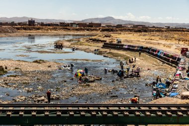 JULIACA, PERU - 6 Kasım 2022: Peru 'nun Juliaca şehrinde Coata Nehri' nde çamaşır yıkayan insanlar