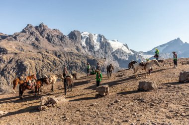 VINICUNCA, PERU - 7 Kasım 2022: Vinicunca Gökkuşağı Dağı altında turistleri bekleyen yerel halk, Peru