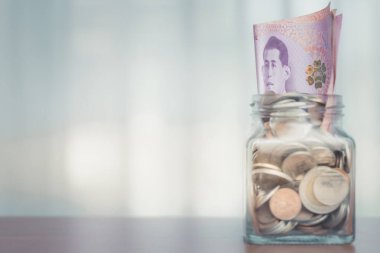 Filtre efektli cam kavanozdaki para geçmişe dönük vintage stil ve finansal büyüme ve tasarruf kavramı için yumuşak odak