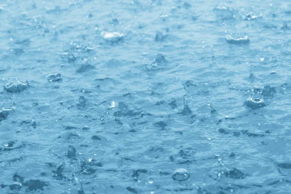 stock image blue color tone of close up rain water drop falling to the floor