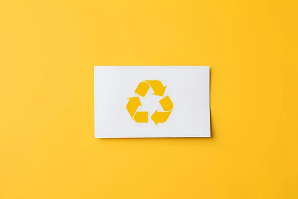 Hand holding card with recycle symbol on yellow background generated AI