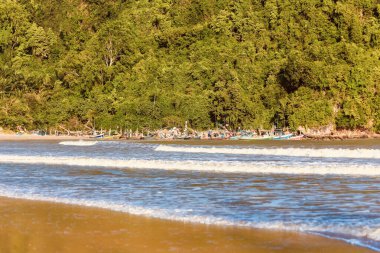 Deniz kenarında küçük balıkçı tekneleri olan bir dağ..