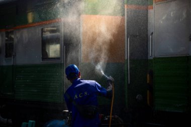 Bangkok, Tayland - 3 Mart: İşçiler Hua Lamphong Tren İstasyonu 'ndaki vagonları temizlemek için su püskürtüyor. 3 Mart 2025 'te