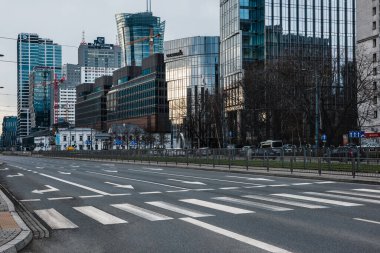 Warsaw, Poland- 09.04.2022: Pedestrian crossing across a wide street against the background of office buildings.