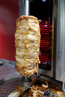 Dönüşümlü tavuk eti paslanmaz çelik ızgarada ızgara ve tipik bir Orta Doğu fast food kebap sandviçinde servis edilmeye hazır.