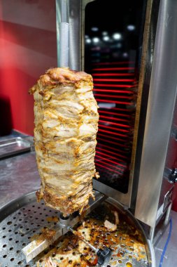 Dönüşümlü tavuk eti paslanmaz çelik ızgarada ızgara ve tipik bir Orta Doğu fast food kebap sandviçinde servis edilmeye hazır.