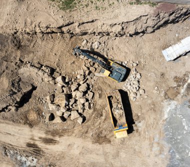 Toprak taşıma ekipmanları. Toprak taşıyıcı ve kamyon makineli inşaat alanının havadan görüntüsü