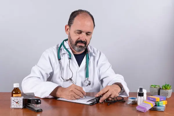 Retrato Del Médico Maduro Sénior Escribiendo Sobre Prescripción —  Fotos de Stock