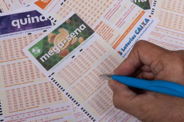 Rio, Brazil - July 20, 2022: person filling out Caixa Economica Federal lottery card, the only official betting method in Brazil