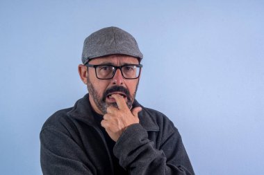 Parmağını ağzına sokmuş 60 yaşında bir adam.