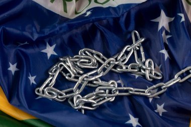 Zincir ve Brezilya bayrağı ülkede köleliği, üst görüşü sembolize ediyor