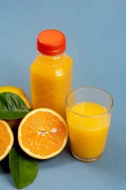 Bardakta doğal portakal suyu, yanında da şişe.