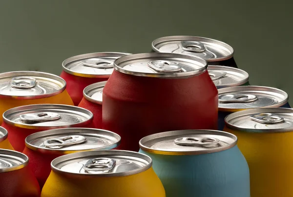 Colored soda cans for conceptual use representing calorie intake and obesity with a red can sticking out of the middle