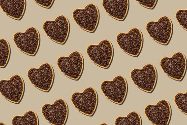 heart shaped tray with coffee beantray with heart shaped coffee bean repeating on brown background