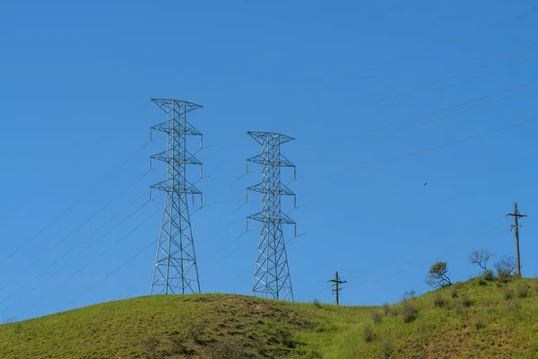 Electric power transmission tower in rural area with blue sky background Electric power distribution infrastructure