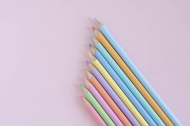 Pastel colored pencils, top view on pink background, illustration concept, background and education and back to school