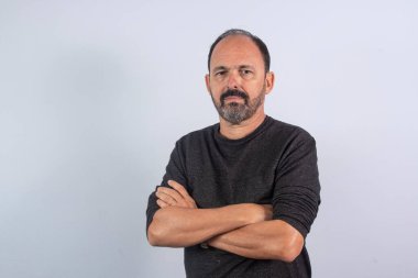 Kameraya bakarak kollarını kavuşturan kıdemli iş adamının portresi.