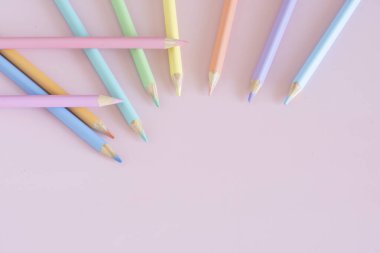 Pastel colored pencils, top view on pink background, illustration concept, background and education and back to school