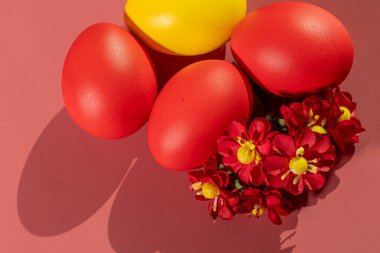 Renkli arka plan ve çiçeklerdeki Paskalya 'yı simgeleyen renkli yumurtalar.