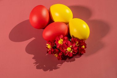 Renkli arka plan ve çiçeklerdeki Paskalya 'yı simgeleyen renkli yumurtalar.