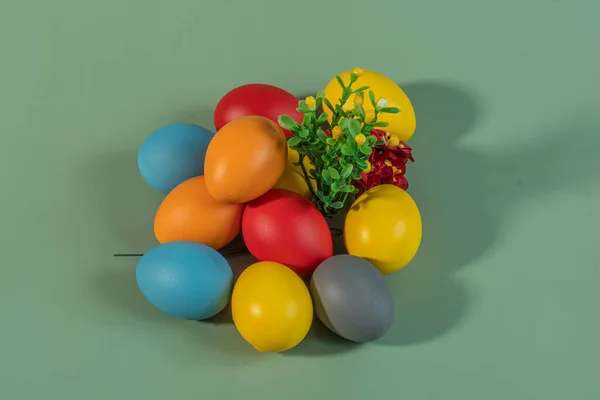 stock image Colorful eggs symbolizing Easter on a colorful background and flowers