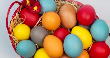 Hristiyan Paskalyasını aydınlık arka planda kutlamak için saman ve yumurta dolu bir sepet.