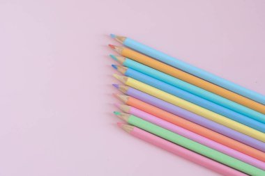 Pastel colored pencils, top view on pink background, illustration concept, background and education and back to school