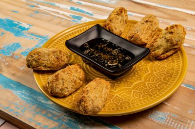 Bir kase zeytinyağıyla porsiyonlar halinde kızarmış morina balığı.