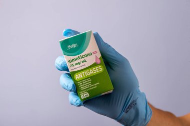 Rio, Brazil - January 27, 2023, hand with protective rubber glove holding medicine box, simethicone