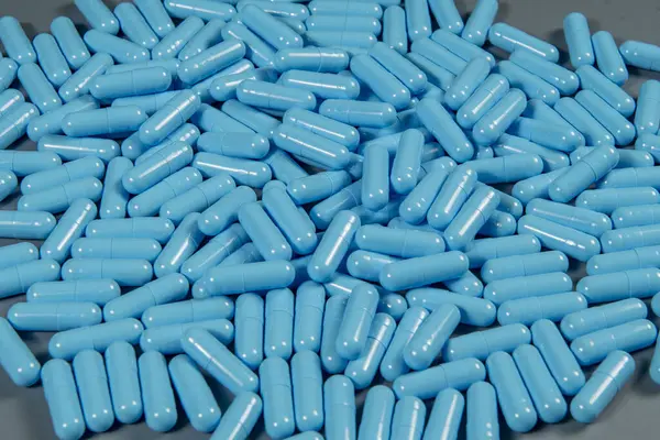 Blue antibiotic capsule pills texture. Pharmaceutical production. Global health. Resistance to antibiotic drugs. Antimicrobial capsule pills, pharmaceutical industry.