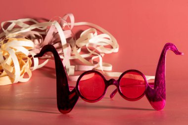 Carnival costume glasses with feathers and typical elements in the background