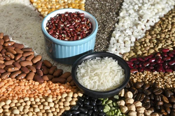 Bowl with raw white rices and beans on various seeds