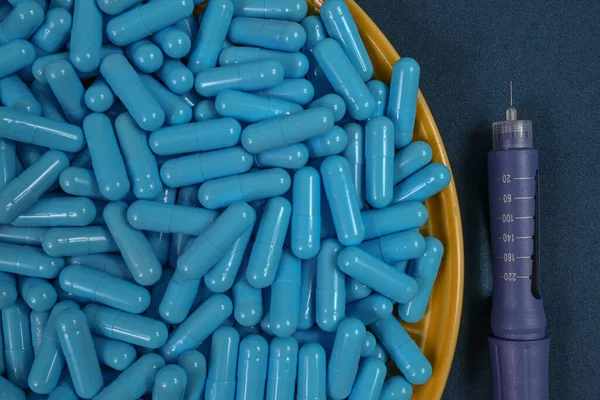 Желтая Тарелка Голубыми Капсулами Лекарств Представляющих Передозировку Лекарств Связанных Диабетом — стоковое фото