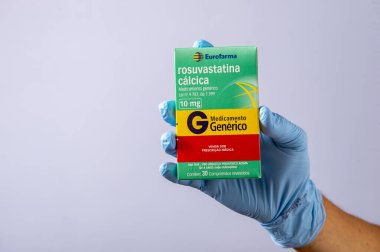 Rio, Brazil - January 27, 2023, hand with protective rubber glove holding medicine box, rosuvastatin calcium