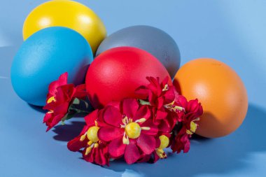 Renkli arka plan ve çiçeklerdeki Paskalya 'yı simgeleyen renkli yumurtalar.