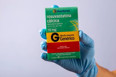 Rio, Brazil - January 27, 2023, hand with protective rubber glove holding medicine box, rosuvastatin calcium