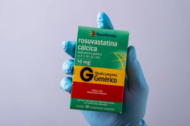 Rio, Brazil - January 27, 2023, hand with protective rubber glove holding medicine box, rosuvastatin calcium