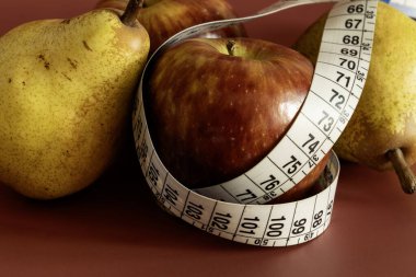 Diyet ve obeziteyi temsil eden mezura ve elma