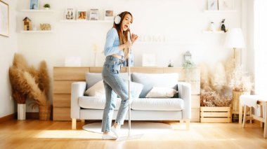 Ev temizliği ve eğlence. Temizlik sırasında en sevdiği şarkıyı söyleyen Asyalı genç ev kadını mikrofon olarak paspası kullanıyor, ev işlerinden zevk alıyor. Genç bir kadın oturma odasında dans edip temizlik yapıyor.