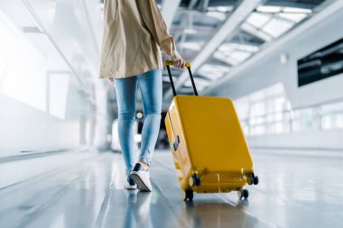 Uluslararası havaalanı terminali. Bavullu ve havaalanında yürüyen Asyalı güzel bir kadın.