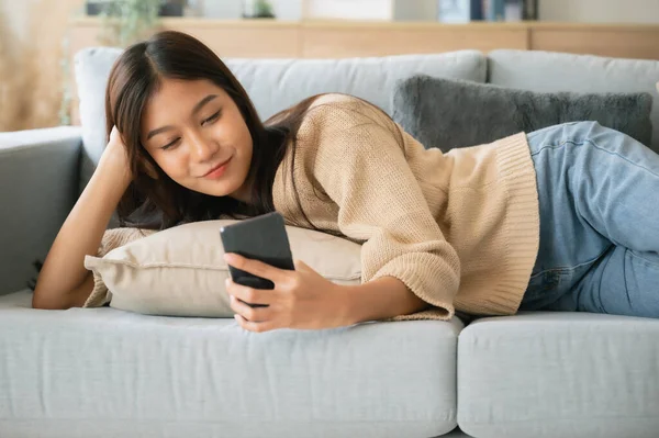 Gelukkig Jong Aziatisch Vrouw Ontspannen Comfortabele Bank Thuis Sms Smartphone — Stockfoto