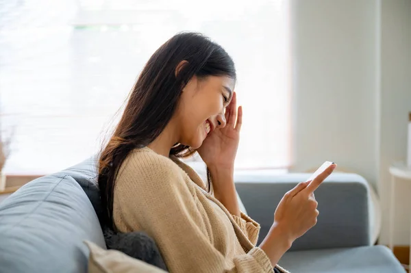 아시아인 여성은 집에서 소파에서 스마트폰으로 메시지를 보내고 소녀는 핸드폰 채팅을 — 스톡 사진