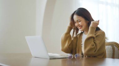 Heyecanlı Asyalı kadın mutlu bir şekilde çevrimiçi zaferi kutluyor. Başarı başarısı, iyi e-posta haberlerinden mutlu olan genç kadın, büyük bir teklifle ya da yeni bir fırsatla motive oluyor, sınavı geçiyor, işe giriyor.