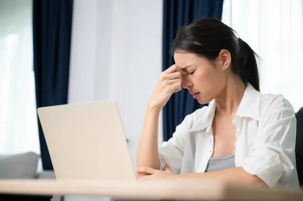 Office syndrome. Overworked tired young asian woman feeling headache, having eyesight problem after computer laptop work. Stressed young woman suffering from fatigue at home