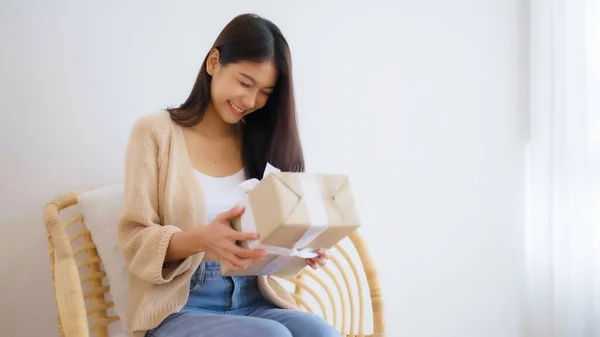 Asian young woman opening a gift box. Happy new year, Thanksgiving